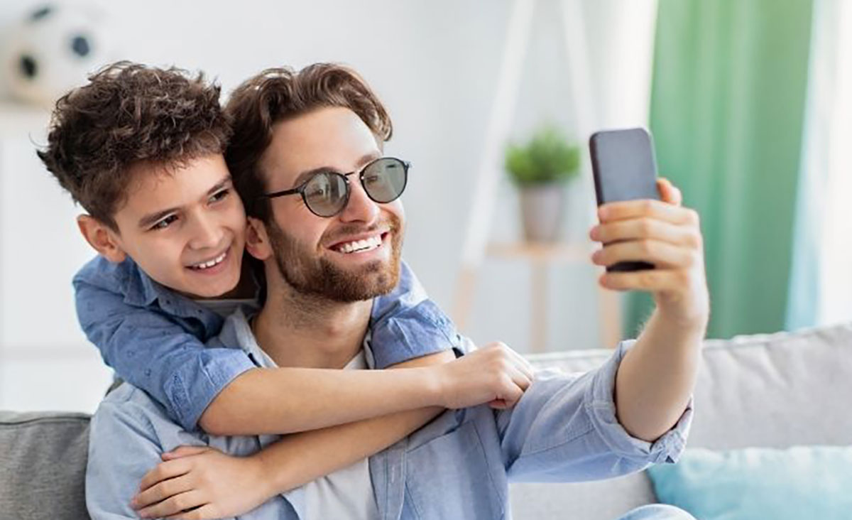 Dad wearing avulux lenses and taking a selfie with his son behind him